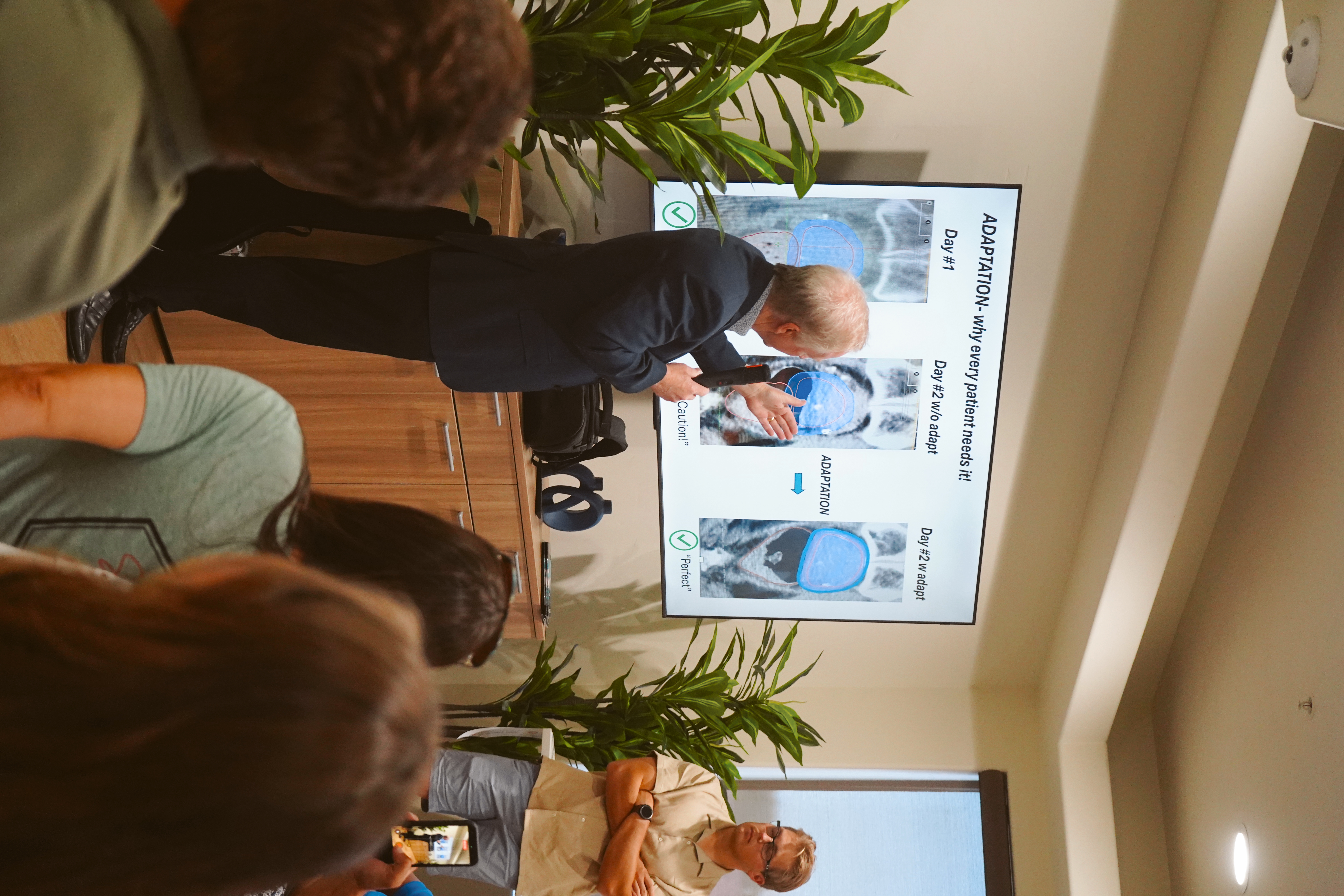 Radiation oncologist explaining adaptive radiotherapy adaptation process to attendees